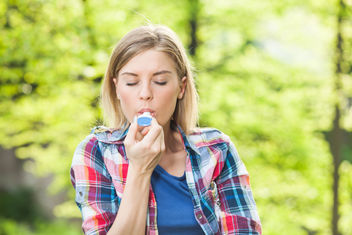 Una mujer usando un inhalador afuera