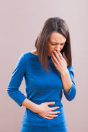 A woman in a blue dress experiencing nausea