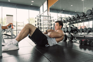 A man doing sit ups in a gym
