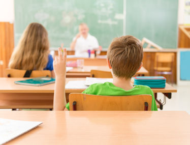 Boy raising hand in classroom