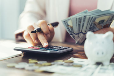 Close up of business woman with calculator counting money