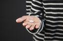 Person holding a large pill in the palm of their hand