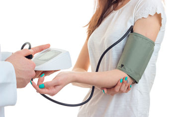 Close-up portrait of a doctor taking blood pressure for a young woman