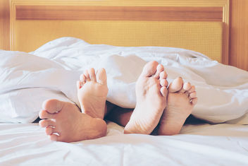 Couples feet sticking out of the covers