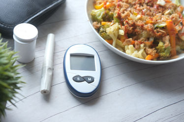 Diabetic measurement tools and healthy vegetables in a bowl