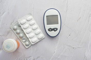Diabetic measurement tools and medical pills on table