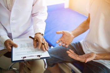 A male physician offering advice and treatment for his patient