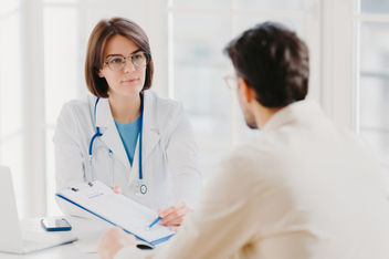 Female doctor discussing alternative prescription options with male patient