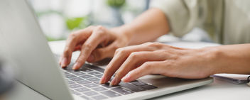 A woman in casual wear using laptop and searching for information