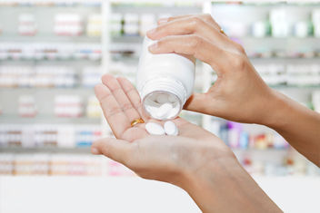 Doctors hand with bottle of white pills