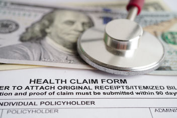 Health claim form with stethoscope and 100 dollar banknotes for medical insurance concept