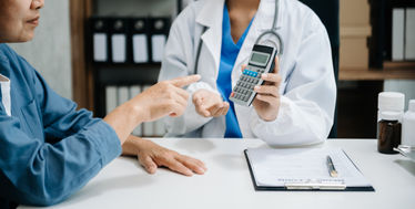 A doctor using a calculator to show his patient medical costs