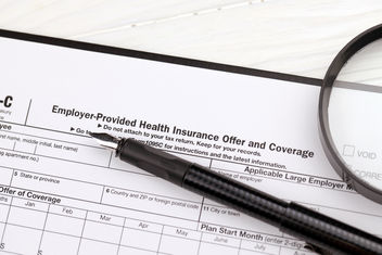 IRS Form 1095-C Employer Provided Health Insurance Offer and Coverage with a black pen