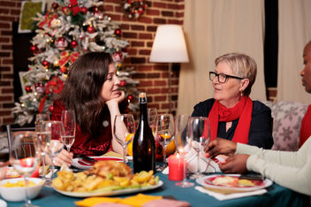 Jolly group of people enjoying a holiday dinner at home