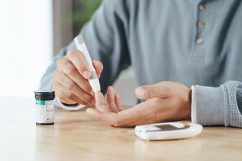 Man using lancet on finger checking blood sugar level