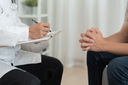 Doctor with clipboard consulting with patient