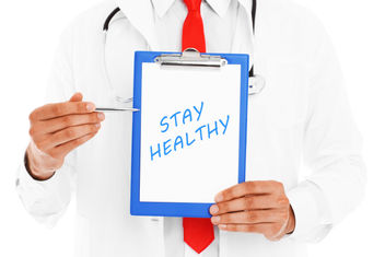 Doctor pointing to a stay healthy inscription