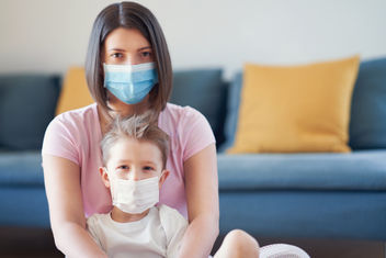 Mother and child putting on protective masks during coronavirus pandemic