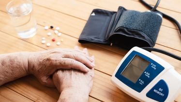 Person with medication and blood pressure monitor