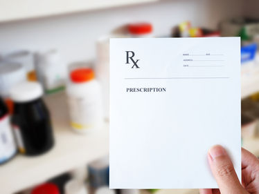 A pharmacists hand with prescription paper at the pharmacy