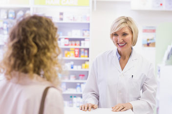 Pharmacist assisting customer at pharmacy counter