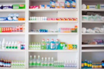 Pharmacy store with blurred medicines arranged on shelves