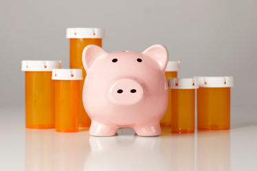 Piggy bank in front of several medicine bottles