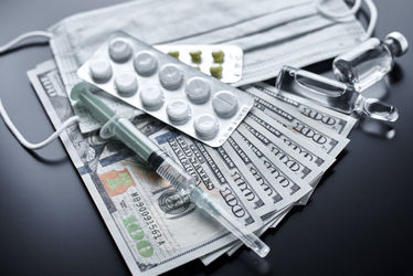 Pills, protective mask, medical items and dollar bills on dark background