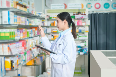 Portrait of female pharmacist using tablet in a modern pharmacy drugstore