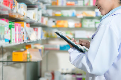 Portrait of female pharmacist using tablet in a modern pharmacy drugstore