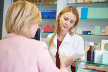 Farmacéutico asesorando a una mujer en farmacia