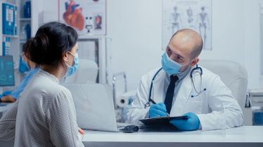 A doctor and patient wearing masks during pandemic