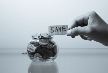 Placing an inscribed save note on a glass money jar