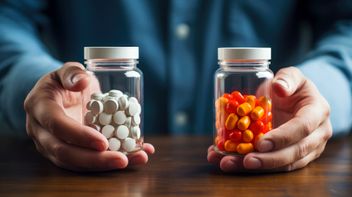 Two clear bottles with different colored pills