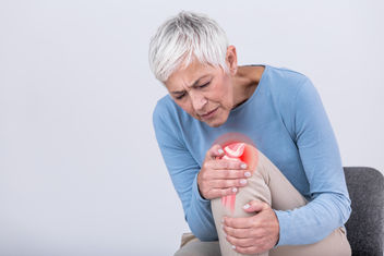 Senior woman holding the knee with pain