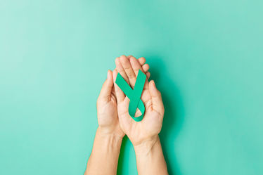 Woman holding teal ovarian cancer ribbon