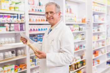 Farmacéutico sonriendo mientras sostiene la receta