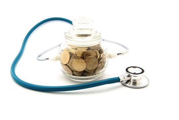 Stethoscope with coins in a glass savings jar 