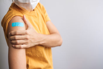 Person showing bandage after vaccination