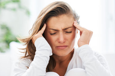 A brunette woman suffering from a migraine
