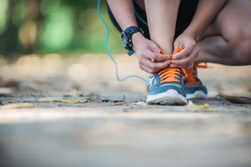 Persona atándose los zapatos para salir a correr