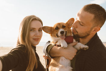 Couple taking selfie with dog on the beach