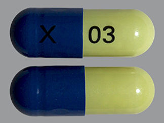 Esto es un Cápsula Dr imprimido con X en la parte delantera, 03 en la parte posterior, y es fabricado por None.