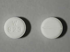 Esto es un Tableta blanco redondo imprimido con W  923 en la parte delantera, nada en la parte posterior, y es fabricado por WOCKHARDT USA L.