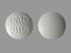 Esto es un Tableta blanco redondo imprimido con PAD   0115 en la parte delantera, nada en la parte posterior, y es fabricado por PADAGIS.