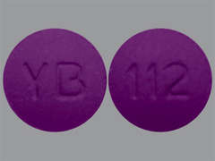 Esto es un Tableta morado redondo imprimido con YB en la parte delantera, 112 en la parte posterior, y es fabricado por TWI/UPSHER.