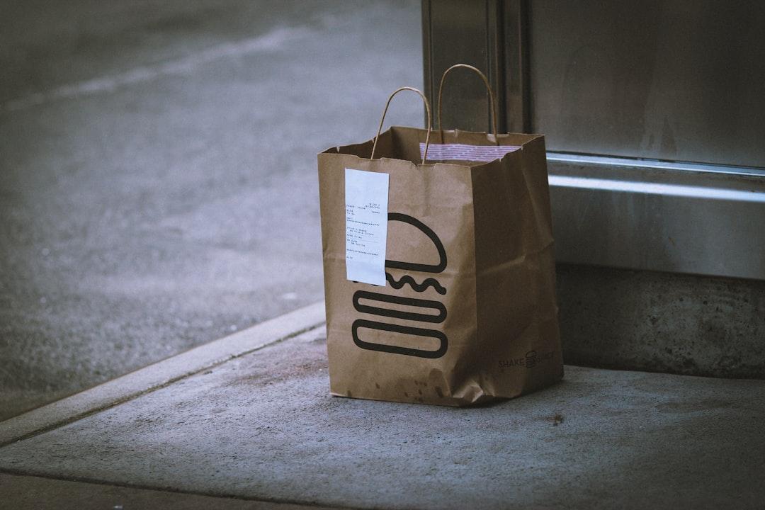 File image: Brown paper delivery bag with handles on concrete doorstep