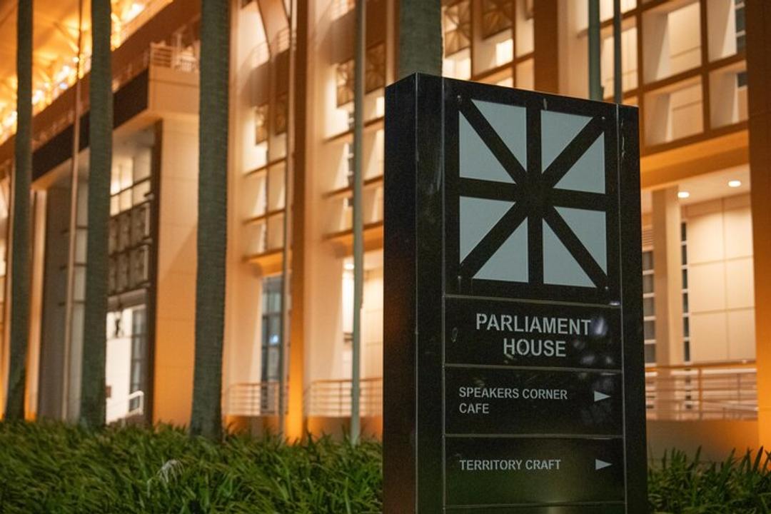 Parliament House illuminated signage at night with directional arrows to cafe and craft venue