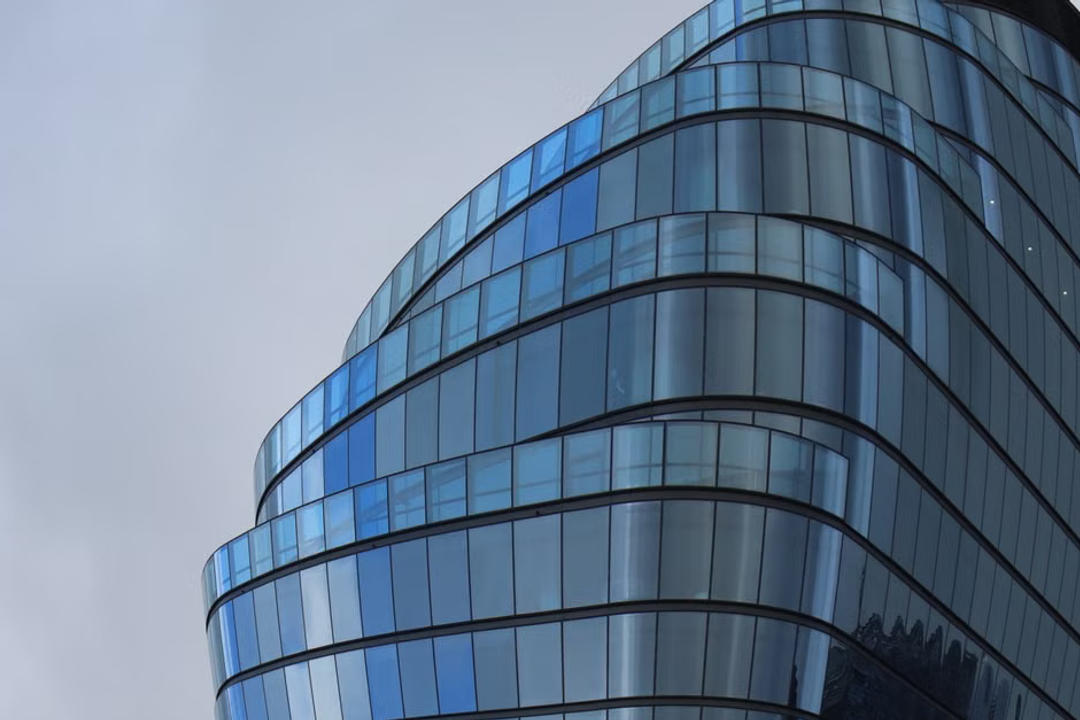 File image: Modern curved glass office tower facade shot from below
