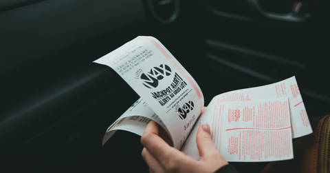 File image: Single hand holding a lottery ticket or print-out with text